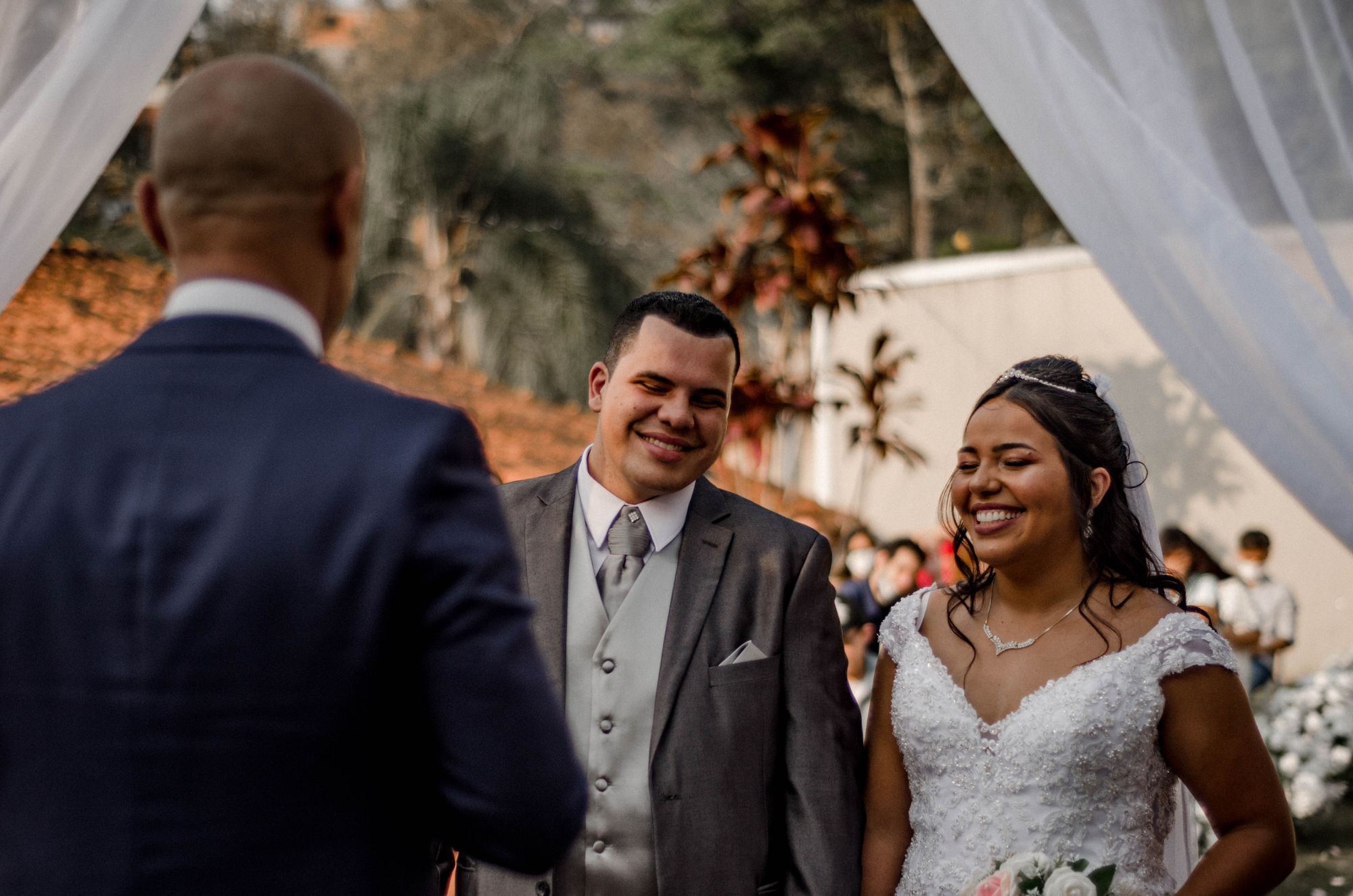 A happy bride and groom smiling during their outdoor wedding ceremony